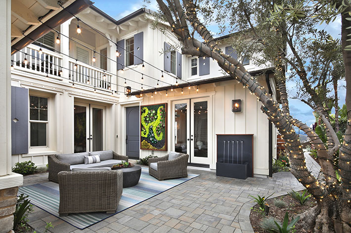 gray paver patio in front of white house near the ocean