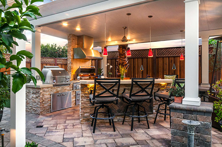 outdoor kitchen under roof held up by white columns