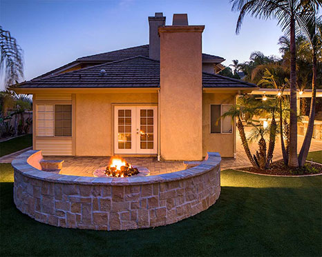 extinguished fire pit with retaining wall in background 