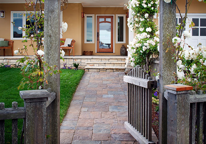 paver slabs next to mini golf leading to outdoor modern minimal kitchen in coastal home